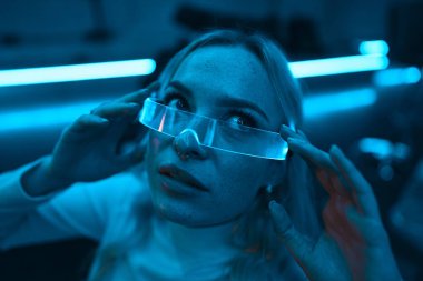 Young woman in neon glasses. Futuristic blonde. High quality photo