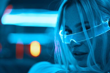 Young woman in neon glasses. Futuristic blonde. High quality photo