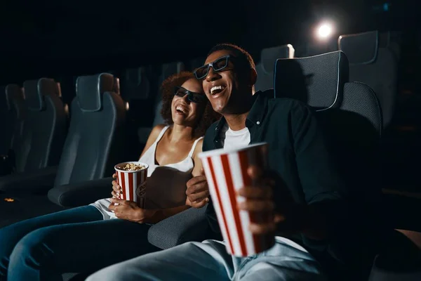 Young people in the cinema. People watch comedy. Young guy and girl are laughing.High quality photo