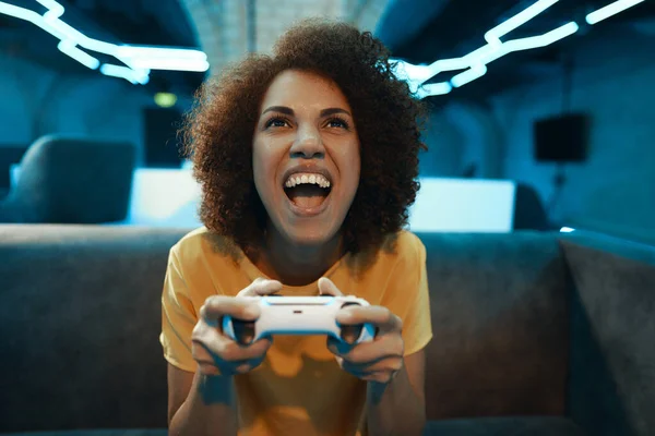 A young woman plays on a console.The emotion of victory, excitement and joy. High quality photo