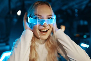 Cute blonde in futuristic fashion style. Neon glasses for a young woman. High quality photo