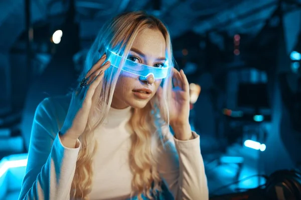 Cute blonde in futuristic fashion style. Neon glasses for a young woman. High quality photo