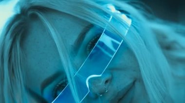 Cute blonde in futuristic fashion style. Neon glasses for a young woman. High quality 4k footage