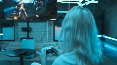 Young female gamer playing console in neon room. High quality 4k footage