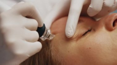 Profesyonel bir kozmetikçi, bir kadına su birikintisi yapar. Cilt bakımı. Yüksek kalite 4k görüntü