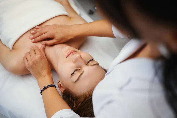 Face massage. Young pretty woman having face massage in the salon. High quality photo