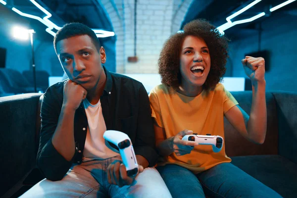 A young woman won a console game from her friend. High quality photo