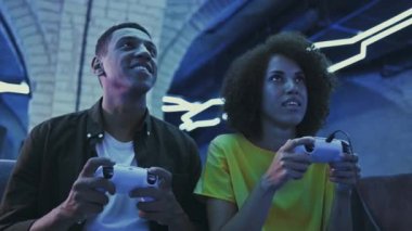 Young people intensively play console games. A man and a woman compete in a game. High quality 4k footage