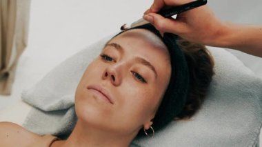 Maskeyi yüzüne fırçayla yapıştırmak. Yüksek kalite 4k görüntü