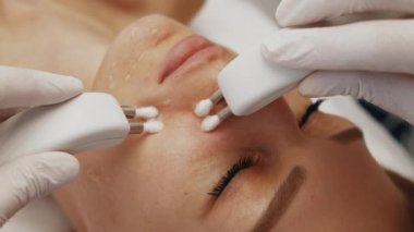 Kadın yüzünün profesyonel temizliği. Mikro akımlarla cilt tedavisi. Yüksek kalite 4k görüntü