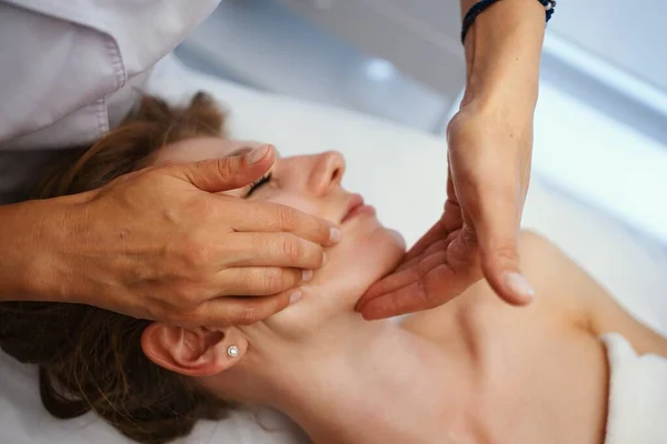 Face massage. Young pretty woman having face massage in the salon. High quality photo