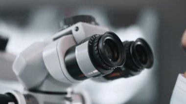 Bir dişçi mikroskop altında bir dişe bakar. Yüksek kalite 4k görüntü
