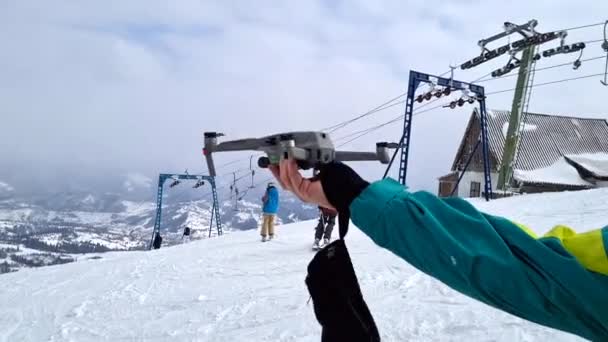 Człowiek startujący drona strzelać ośrodek narciarski zima — Wideo stockowe