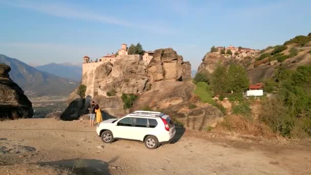 Para podróżnik w pobliżu samochodu SUV patrząc na szablony w górach szczyt — Wideo stockowe