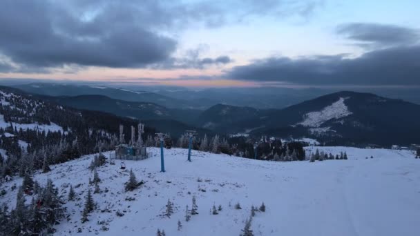 Ηλιοβασίλεμα πάνω από το χιονοδρομικό κέντρο στα χιονισμένα βουνά — Αρχείο Βίντεο