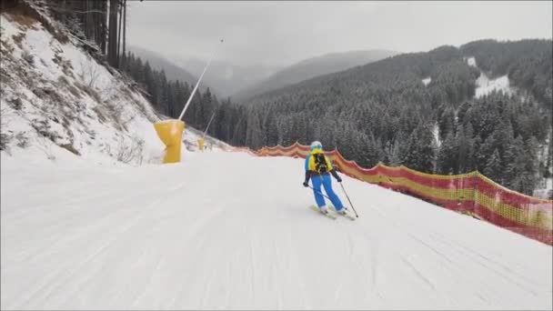 Mujer esquiando por pendiente en la estación de esquí — Vídeos de Stock
