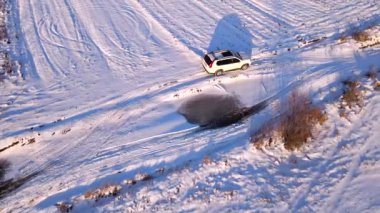 Karlı arazi yolunda arazi aracının hava görüntüsü.