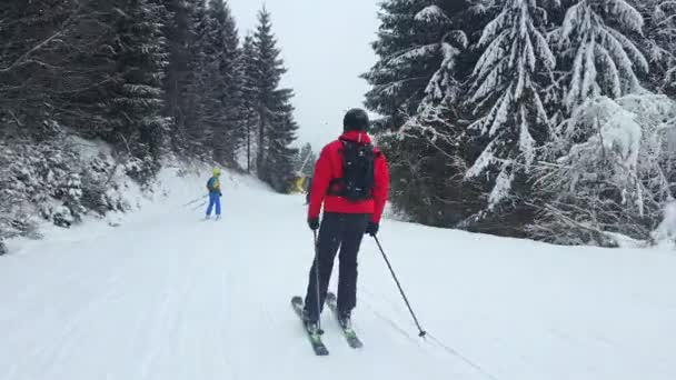 Bukovel, Ουκρανία: 13 Ιανουαρίου 2021: άνθρωποι που κάνουν σκι στο χιονοδρομικό κέντρο χιονόπτωση — Αρχείο Βίντεο