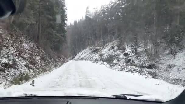 Auto durch verschneite Bergstraße gefahren — Stockvideo