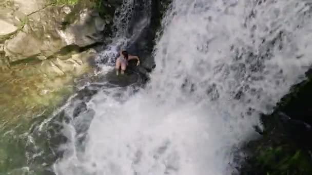 Young woman resting swimming in waterfall — Stock Video
