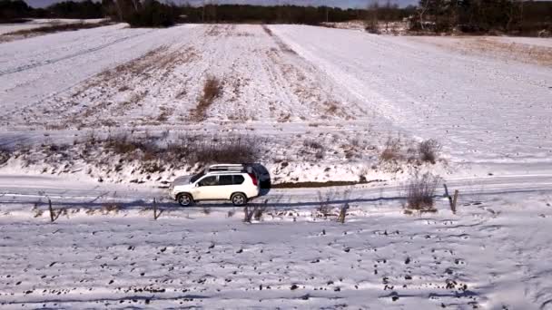 Εναέρια άποψη του SUV αυτοκίνητο κινείται από χιονισμένο πεδίο — Αρχείο Βίντεο