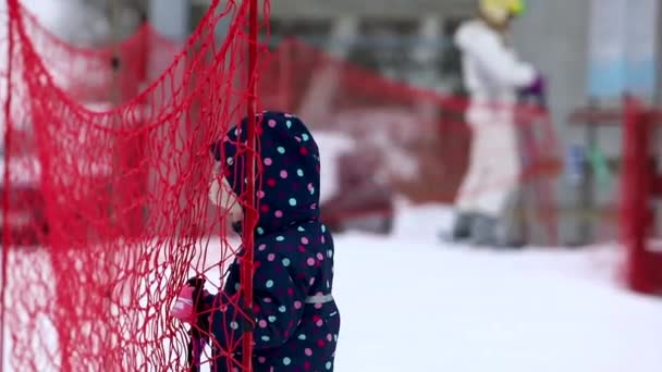 Majdan, Ukraina - 20 lutego 2021: mała dziewczynka uczy się jeździć na nartach — Wideo stockowe