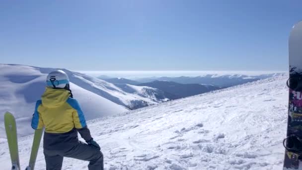 Pareja esquiador y snowboarder mirando increíbles montañas nevadas vista — Vídeos de Stock