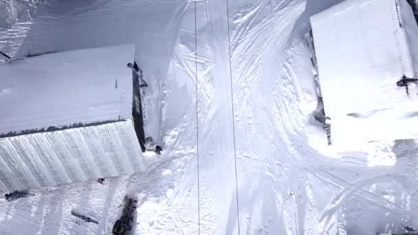 Vista aérea del pico de la montaña personas esquiando y snowboard — Vídeo de stock