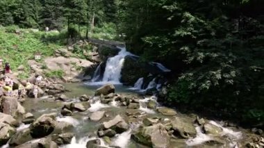 Kamyanka, Ukrayna - 20 Temmuz 2021: Ukrayna 'daki Ukrayna Karpatlar' daki şelalenin turistlerle birlikte havadan görünüşü