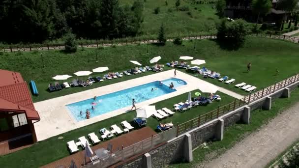 Luchtfoto van mensen die in de buurt van het zwembad rusten — Stockvideo