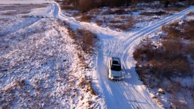 Karlı arazi yolunda arazi aracının hava görüntüsü.