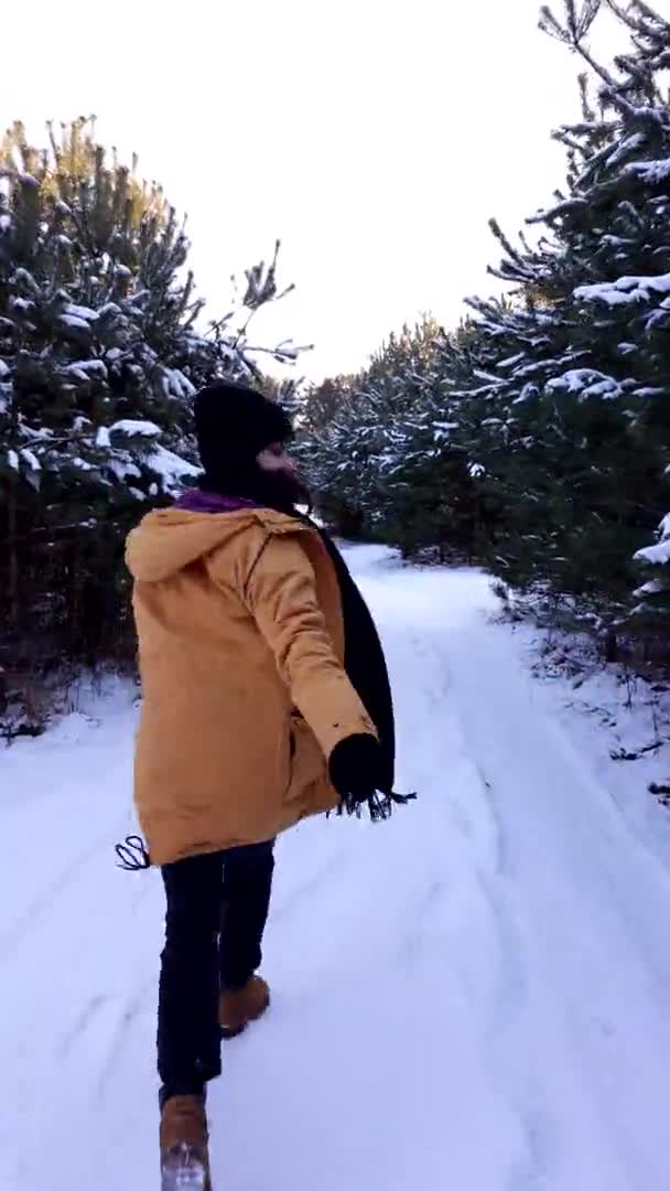Mujer corriendo por bosque nevado con pinos — Vídeos de Stock