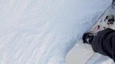 Dağların yamacında kayak yapan bir kadın.