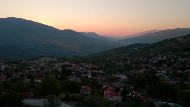 Antenn utsikt över soluppgången över grekisk by vid Thessaly bergen — Stockvideo