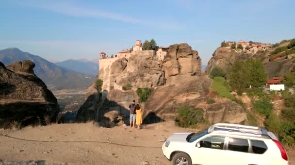 Casal viajante perto de carro SUV olhando para modelos no pico das montanhas — Vídeo de Stock