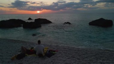 Çiftler gün batımında sahilde buluştu.