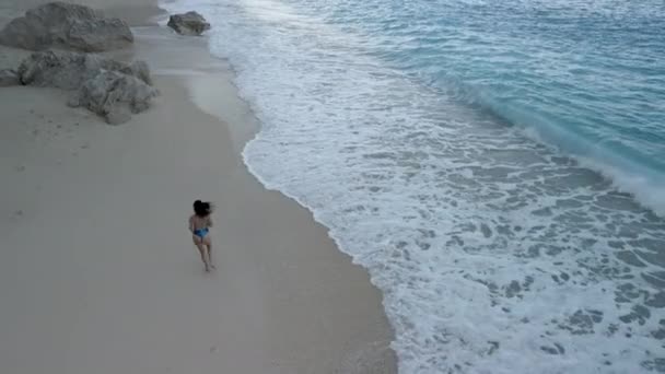 Jong sexy vrouw in badpak lopen door zee strand — Stockvideo