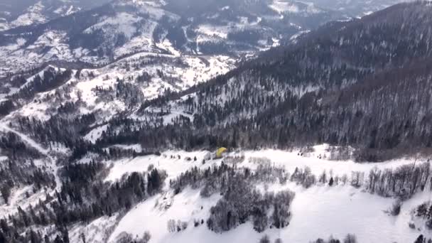 스키 리조트 위에 떠 있는 스키어 패러글라이더 — 비디오