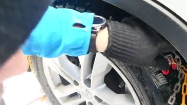 Dragobrat, Ocak - 13, 2021: Adam araba tekerleğine zincir taktı