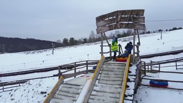 Lwów, Ukraina - 30 stycznia 2021: rodziny bawiące się w snowtubing parku — Wideo stockowe