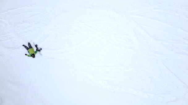 Man klättrar upp av snöiga backen med snowboard — Stockvideo