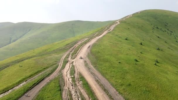 Εναέρια άποψη SUV όχημα ανεβαίνει από το λόφο στην κορυφή του βουνού — Αρχείο Βίντεο
