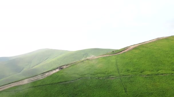 Εναέρια άποψη SUV όχημα ανεβαίνει από το λόφο στην κορυφή του βουνού — Αρχείο Βίντεο