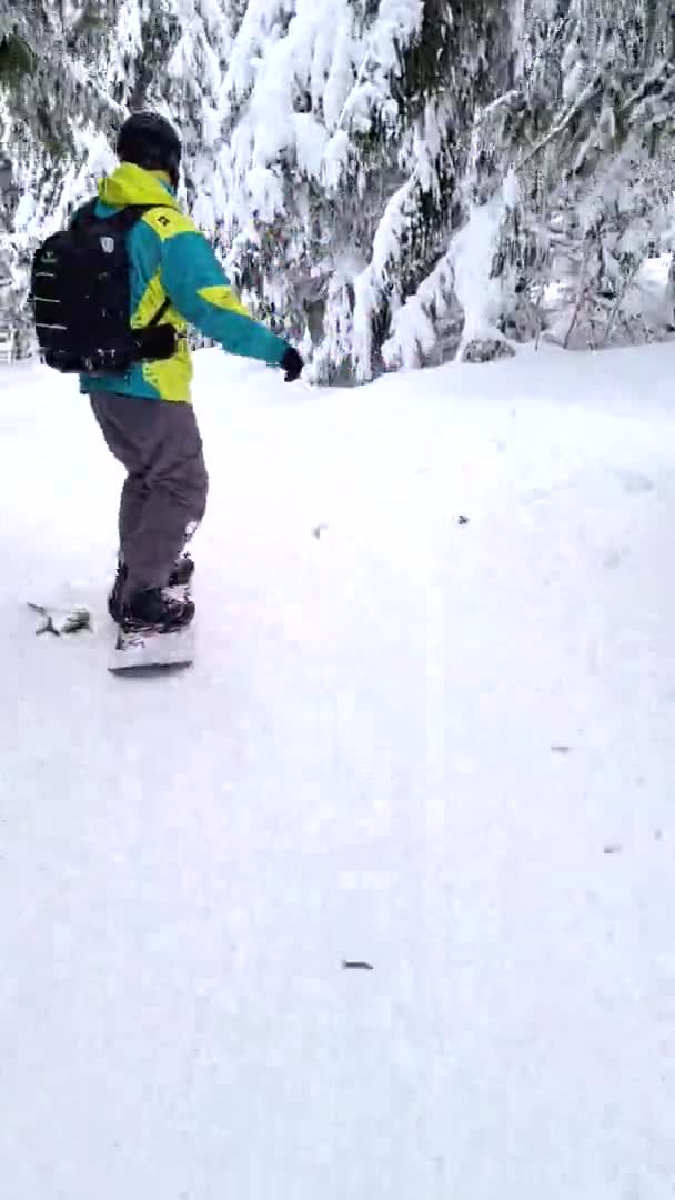 Άνθρωπος snowboarder ιππασία από χιονισμένη πλαγιά σε όμορφα βουνά — Αρχείο Βίντεο