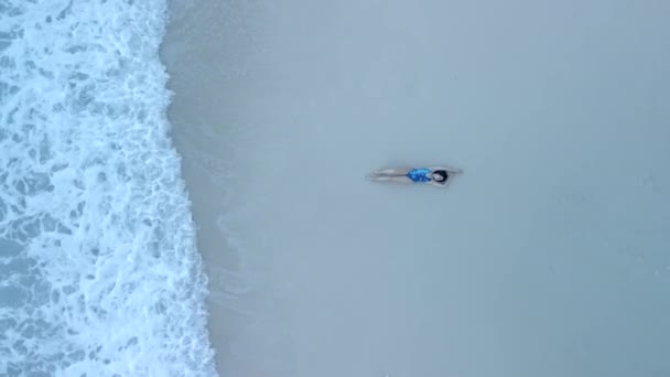 Vista aérea de la mujer en traje de baño en la playa de mar — Vídeos de Stock