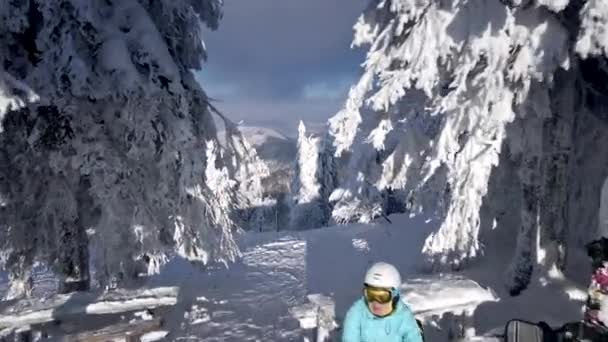 Женщина лыжник сидит на скамейке на вершине гор — стоковое видео