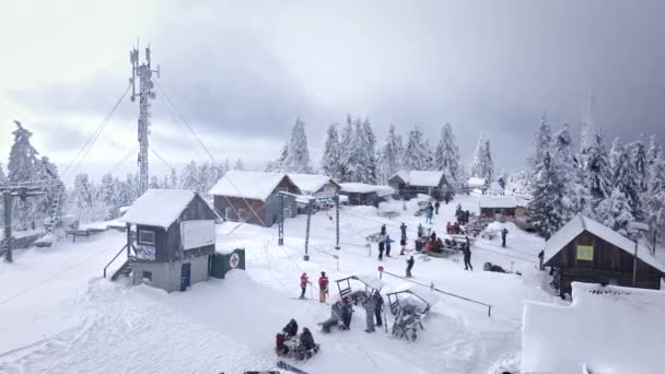 Vista aérea do pico da montanha pessoas esqui e snowboard — Vídeo de Stock