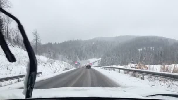 Водіння автомобіля на зимовій дорозі в горах — стокове відео
