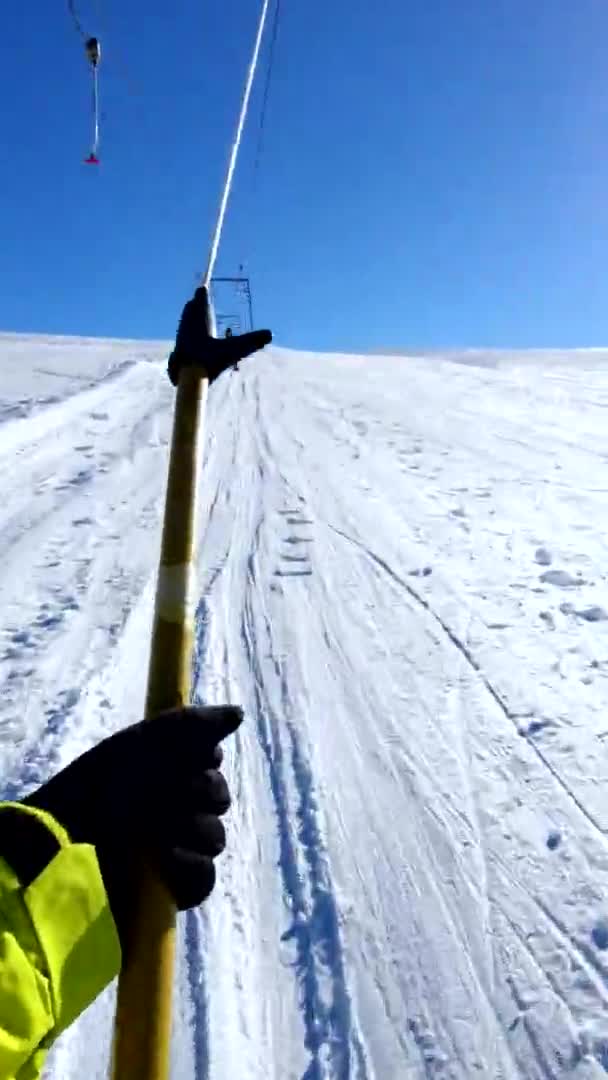 Snowboarder bei Drogenfahrt mit Pistenraupe bergauf — Stockvideo