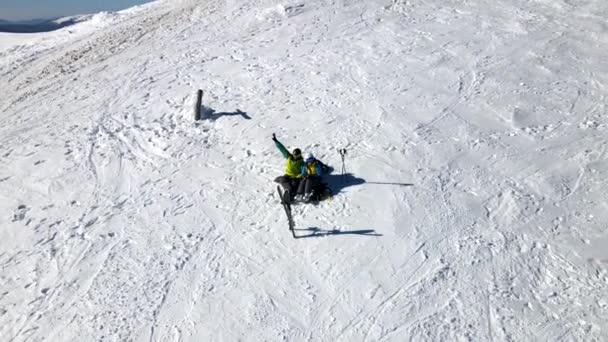 Pareja esquiador y snowboarder divertirse en la cima de la colina en el día soleado — Vídeo de stock